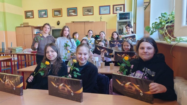 Zdjęcie uczennic z kwiatami i bombonierkami, które dostały na dzień kobiet
